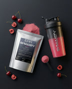 Cherry-flavored EAA Vitamin B6 powder pouch, shaker, scoop, and fresh cherries on black background